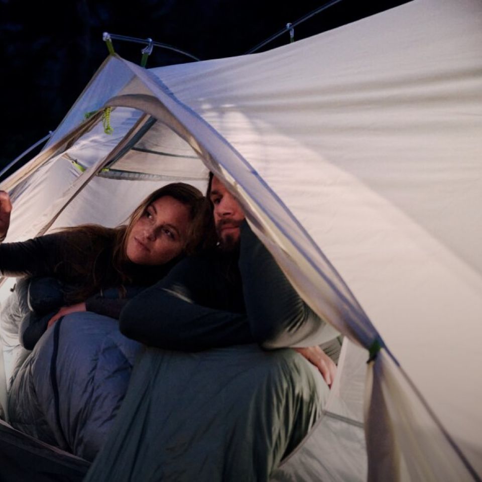 A woman and a man in a tent in darkness
