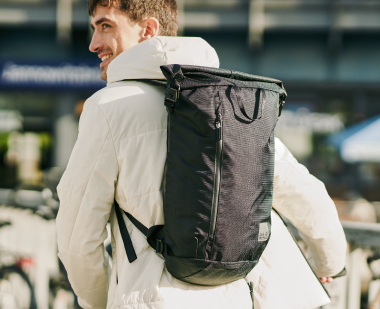 Man carrying a rolltop pack on his back