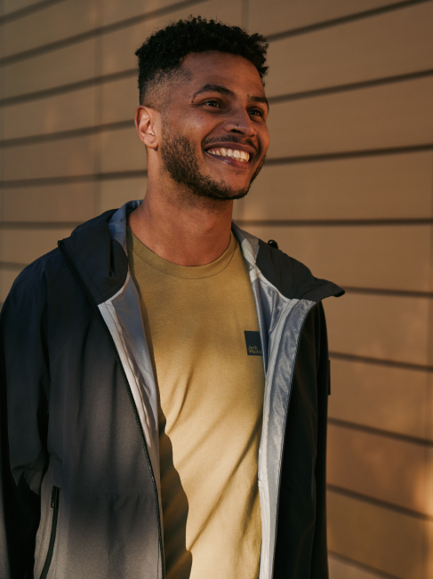 A man in a black jacket smiling